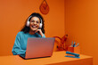 © Jacob Lund - Joyful young woman listening to music and laughing while working on laptop