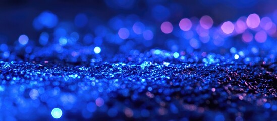 Wall Mural - Blue glittering texture with bokeh effect featuring sparkles and reflections on a dark background suitable for abstract designs and wallpapers. Copy Space