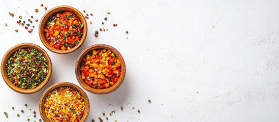 Wall Mural - Colorful vegetable salsa in wooden bowls arranged on white background with scattered spices and herbs, Copy Space