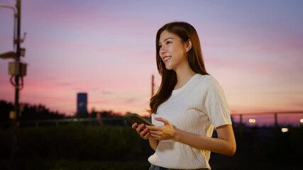 Wall Mural - Smiling woman enjoys outdoor smartphone communication at sunset, capturing happiness in evening lifestyle filled with technology and joy. Asian Digital technology lifestyle