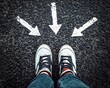 © Mona - Design - white Sneakers shoes and arrows pointing in different directions on asphalt floor, life and studies choice for young people concept