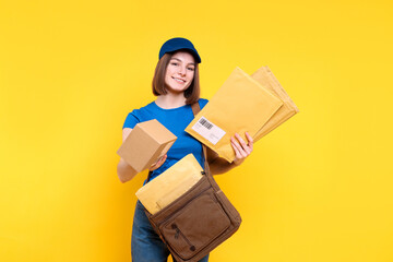 Poster - Happy postwoman with bag and envelopes giving parcel on yellow background