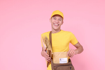 Poster - Happy postman with bag and envelopes on pink background