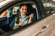 © Mediteraneo - Young businesswoman putting a seatbelt on. Ready to drive off from his parking spot in an underground garage.