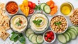 © Pat J. - A flat lay of healthy snacks, including sliced veggies, hummus, and whole-grain crackers, on a white table. Perfect for a balanced diet