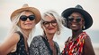 © liliyabatyrova - Three diverse middle-aged women stand together on a beach, radiating joy and confidence. Their fashionable outfits and accessories reflect their vibrant personalities as they soak up the sun