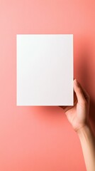 Leinwandbilder - Hand holding a blank square paper on a pink background in a creative workspace setting. Generative AI
