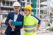 © JackF - Civil engineer and a young woman worker working on a construction site discuss a construction plan, make important notes ..on tablet