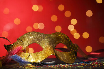 Wall Mural - Beautiful carnival mask and confetti on color background with blurred lights, closeup