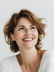 Wall Mural - Radiant Woman: A portrait of a woman with a joyful expression, short wavy light brown hair, and a bright smile, looking upward with hope and optimism.