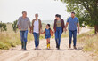 © peopleimages.com - Holding hands, family and walking with child on farm for love, care or support with grandparents on dirt road. Smile, mother and father with girl in countryside for travel, agriculture or generations