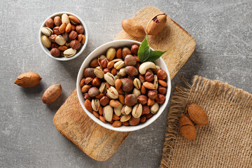 Wall Mural - Assorted nuts in white bowls on a gray background