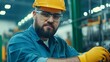 © chusnul - Focused worker in safety gear using tools in a busy industrial workshop with machinery in background