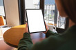 © Farknot Architect - Mockup image of a woman holding digital tablet with blank desktop screen in cafe