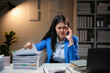 © Crystal - Stressed Asian businesswoman looking at documents while working late in office