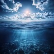 © Duskcraft - Dramatic ocean view with sun rays piercing the surface and clouds above a deep blue sea