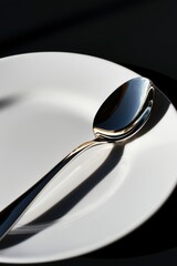 Wall Mural - A silver spoon rests on a white plate