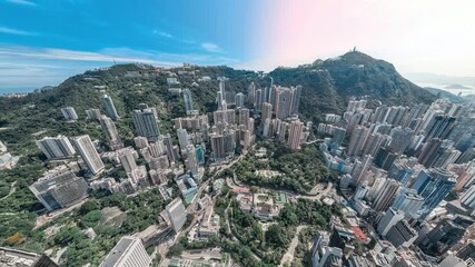 Poster - A 4k still video frame shows a zoomed-out aerial view of Hong Kong's dense cityscape nestled amongst lush green hills.
