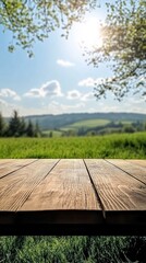 Wall Mural - Rustic wooden table top with a scenic view of green hills and sunny sky in the background
