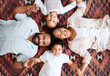 © peopleimages.com - Top view, holding hands and happy family with portrait in home for love, bonding or security. Smile, parents and kids siblings on living room floor with support, protection and relationship in Mexico