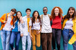 © Xavier Lorenzo - Portrait of seven young student friends leaning on blue wall. Youth and education concept