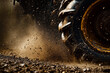 © TiA - Spinning tractor tire kicking up dirt and mud