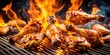 © udomsak - Sizzling chicken legs and wings on a grill with intense flames, surrounded by a smoky atmosphere
