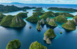 © AmazingAerialAgency - Aerial view of beautiful tropical islands and turquoise lagoon with lush greenery, Raja Ampat Regency, Indonesia.