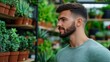 © fotogurme - Man browsing potted succulents and small cacti in a chic floral shop with modern decor and natural wooden shelves