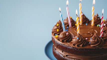 Canvas Print - a chocolate cake with lit candles, decorated with swirls of frosting and colorful sprinkles, on a bl