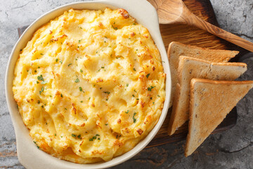 Wall Mural - Close-up of mashed potato casserole with cheese, cream and butter in a baking dish on the table. Horizontal top view from above