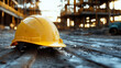 © Alex - Yellow hard hat on muddy ground at an active construction site