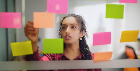 close up of indian young adult gen z woman lady read new notes look task data day time office glass 