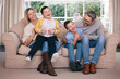 © peopleimages.com - Tickle, laughing and parents with kids on sofa for bonding, happy relationship and relax in living room. Family, home and couch with mom, dad and children for playing, having fun and silly together