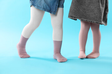 Wall Mural - Kids wearing tights on light blue background, closeup