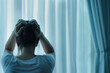 © Artinun - Patient struggling with mental health in a bedroom setting. Person pulling at their hair, indicating psychiatric distress The curtain in the background adds to the sense of isolation and introspection