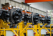 © Кристина Пахомова - A row of black and silver tire axles on a yellow stand.