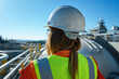 © smth.design - Caucasian woman engineer in high visibility gear inspecting industrial facility