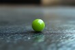 © Diki prayoga - A single green sphere rests on a dark surface