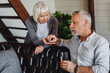 © InsideCreativeHouse - Elderly woman giving her sick husband a glass of water with pills at home. Wife cares for his health. Senior couple, man taking medicine or vitamin supplements for treatment.