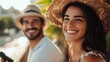 © The 2R Artificiality - happy young couple enjoying leisure time outdoors with remote controller in tropical setting, smiling woman in straw hat and man in summer attire