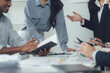 © Wicitr - Collaborative Brainstorming: A diverse group of business professionals engage in a dynamic discussion, reviewing documents and sharing ideas in a modern office setting.