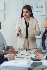 Wall Mural - Business Presentation:  A confident businesswoman leads a diverse team in a productive meeting, fostering collaboration and driving ideas forward. The atmosphere is professional and focused.