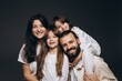 © Максим Галінский - A young sincere family where a stylish bearded father and a cute wife hold their cute children in their arms. Family photo shoot in the studio