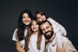 © Максим Галінский - A young sincere family where a stylish bearded father and a cute wife hold their cute children in their arms. Family photo shoot in the studio