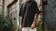 © pier - oversized black t-shirt mockup worn by young man with tattoos and white pants in streetwear style