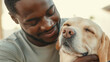 © Bonsales - Close-up of a smiling dark-skinned male groomer embracing a relaxed labrador dog with closed eyes, showing a tender moment of affection and care between human and animal