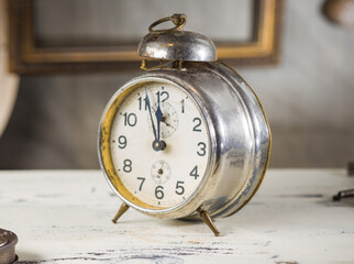 Vintage alarm clock, showing time around 11.55. Retro design with aged details.