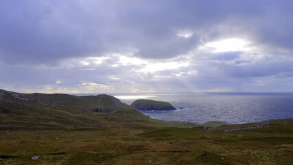 Wall Mural - Arranmore Island in Donegal IrelandA breathtaking and stunning view of coastal hills seamlessly meeting the vast ocean beneath a moody, dramatic sky