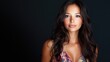 © The 2R Artificiality - studio portrait of an attractive young woman with long brunette hair wearing a floral top against a dark background highlighting her confident expression